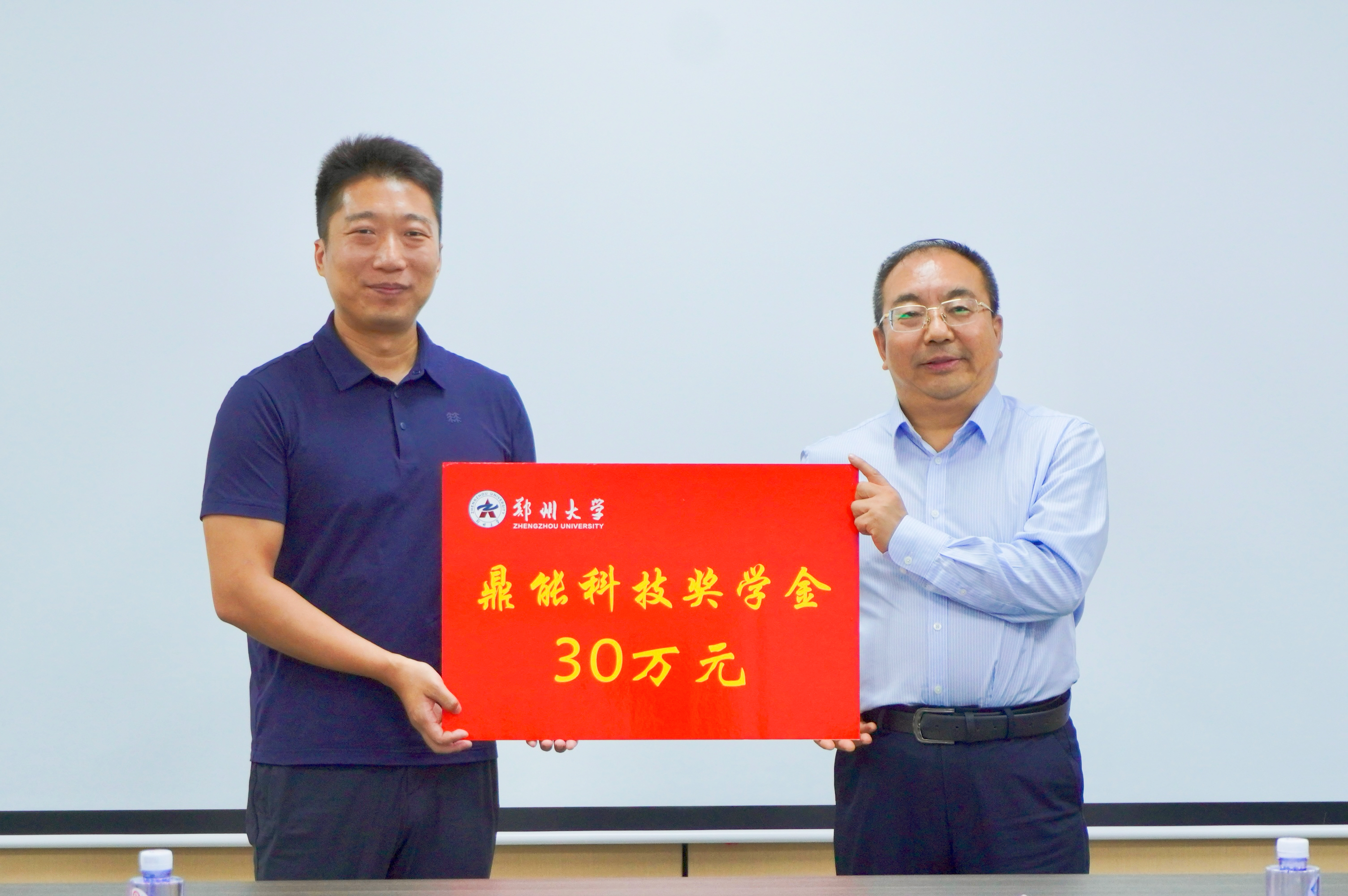 8王瑞波书记接受陈磐总裁捐赠.jpg